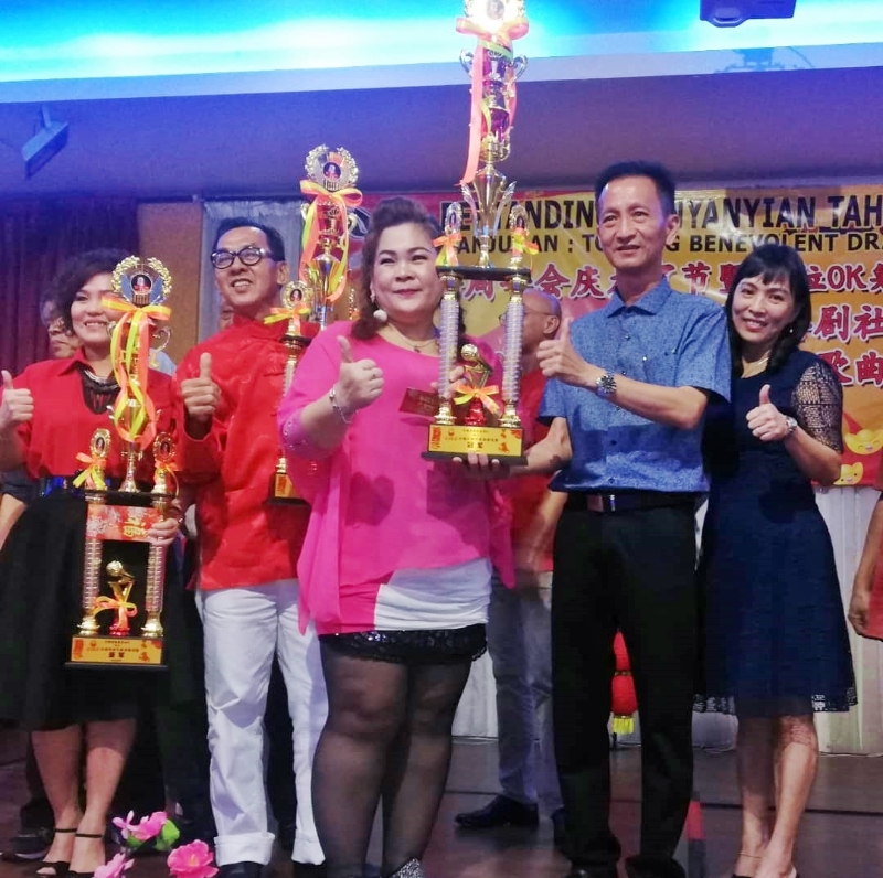 方美敏（右起）、黄溶筌颁发奖杯给歌赛优胜者艾芬、罗亚鹏、杨佩丽。