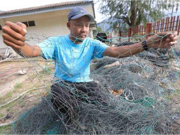 彭亨州渔业局海洋公园与资源组工作人员展示“鬼网”，并强调这些海洋垃圾对海洋生物尤其是海龟生存带来极大的威胁。(图片由渔业局提供)

