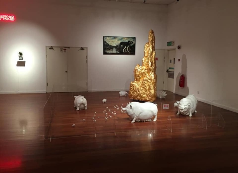 被撤下的阿末弗亚作品，原本可见有5头白色猪只造型的装置摆设，围著一座金山绕行。