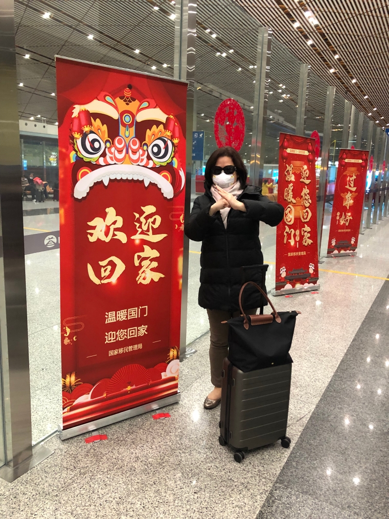 Claudia与丈夫在大年初二按照计划回到北京，机场到处写着“欢迎回家”的标语，差别是乘客比平常稀少，许多人戴着口罩。