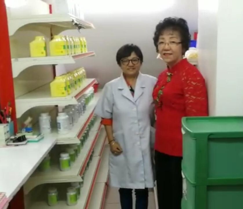  黄燕君(右)与冯雪贞医师巡视医药部中药储存室。