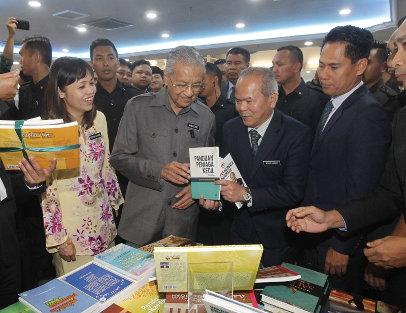  马哈迪（左二）在国大为10年阅读计划主持推介后，参观展示的书籍。右二为加沙里，左一为张念群。