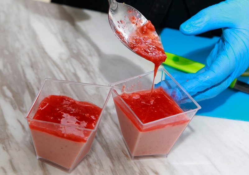 7.把冷却的草莓配料倒入冷藏的布丁杯，并在表层加入草莓作为装饰。