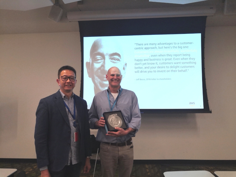邓章钦（左）赠送纪念品予亚马逊公司业务发展主任罗杰。