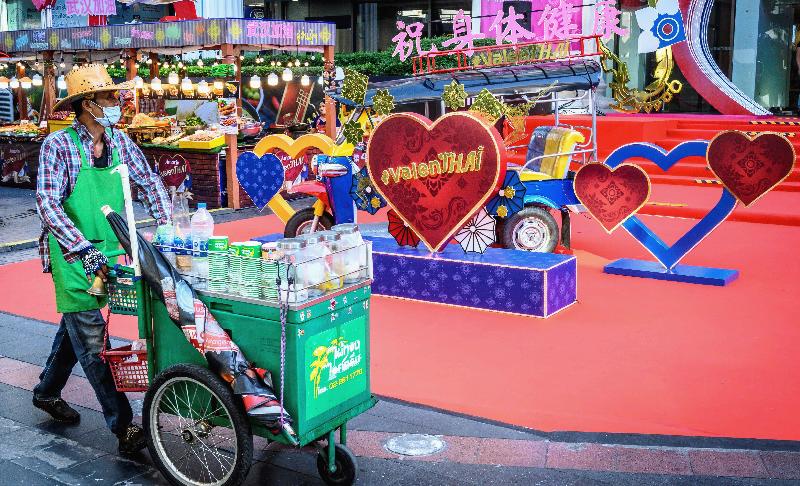 A street food vendor pushes his cart in front of Valentine's Day decorations outside a shopping mall in Bangkok. AFP