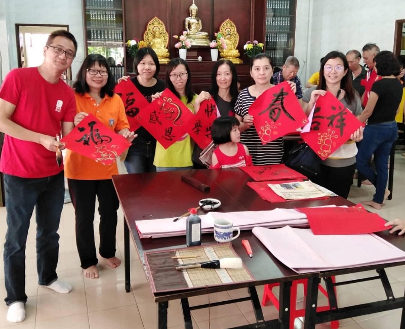 叶景华(左起)将现场挥毫的墨宝赠送于话望生华小校长刘雁心及教师。