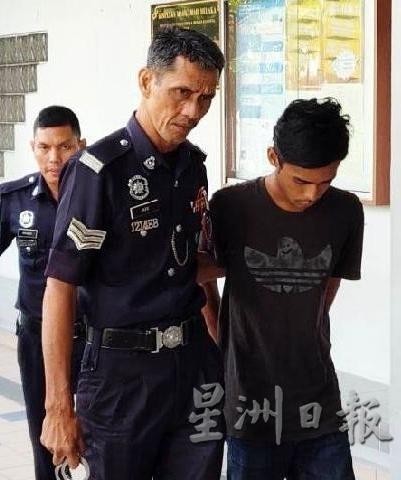 被告莫哈末艾迪尔（右一）在庭警的押送过程低着头。