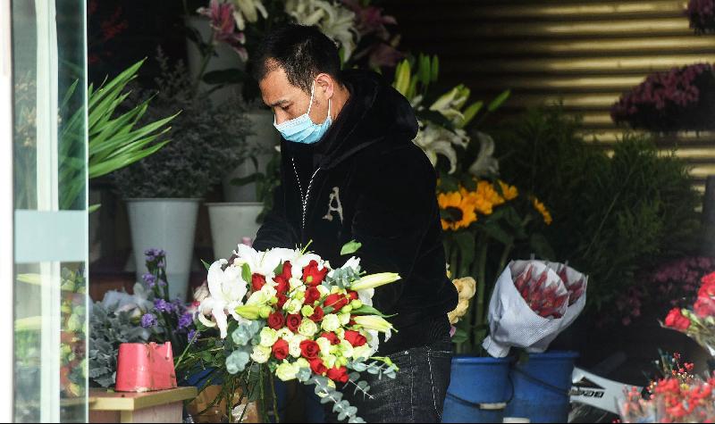 A florist packages flowers at his shop in Hangzhou in China's Zhejiang province, as Chinese couples settle for a quiet Valentine's Day this year on coronavirus fears. AFP
