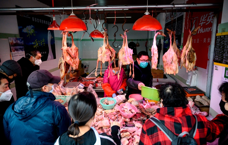 上海民众戴口罩上菜市场购买鸡肉。　（法新社照片）