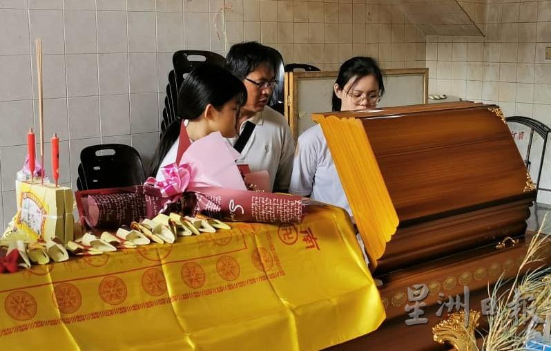 林国兴和2名女儿瞻仰死者遗容。