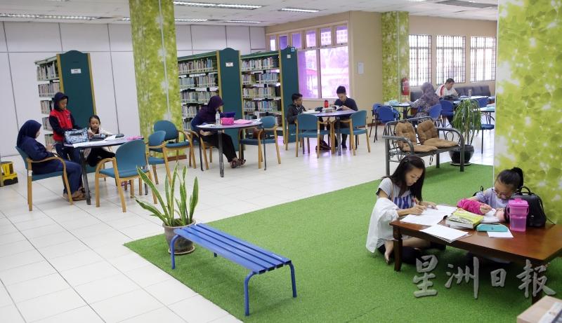 除了在普通桌椅，图书馆内也有一方角落铺上假草，让你可以席地而坐随性阅读，非常自在。（图：星洲日报） 