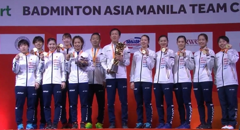 日本女队击败韩国赢得亚洲团体锦标赛冠军，完成卫冕。图为日本羽总总教练朴柱奉（中）和弟子们手举奖杯及奖牌来张大合照。（图：互联网）