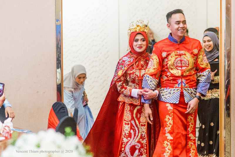 穿龙凤褂步入婚礼会场的穆斯林新人沙菲克与努沙菲嘉（彭美美），脸上洋溢着幸福的笑。（图：Pan Productions）