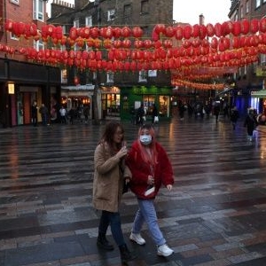 A visitor wears a face mask as she walks through London's Chinatown. AFP