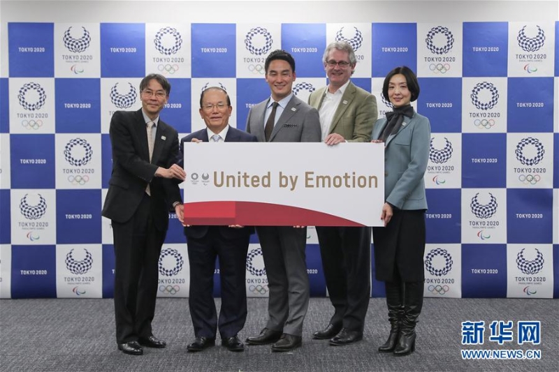 東京奧組委首席執行員武藤敏郎（左二）和東京奧運會口號選定委員會成員與東京奧運會和殘奧會口號“United by Emotion”合影。 （新華社照片）