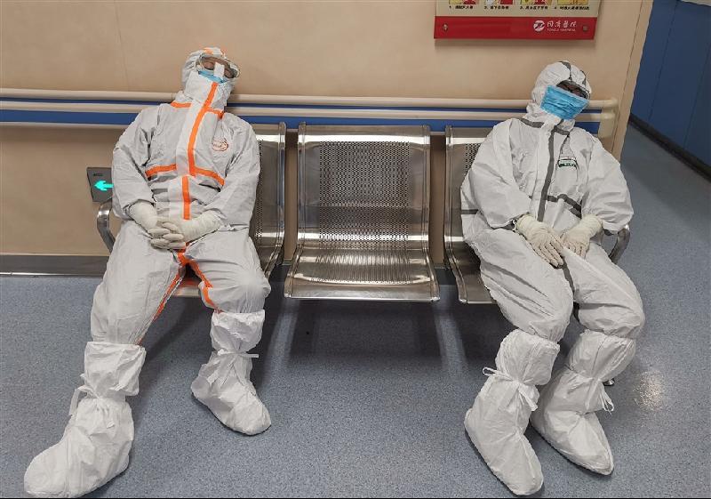 中国湖北省官员表示，对抗致命武汉肺炎疫情的中国第一线医护人员子女，将能在申请学校及高等教育的考试中加分。图为湖北同济医院两名医护人员在病房外的椅子上休息。（图：中新社）