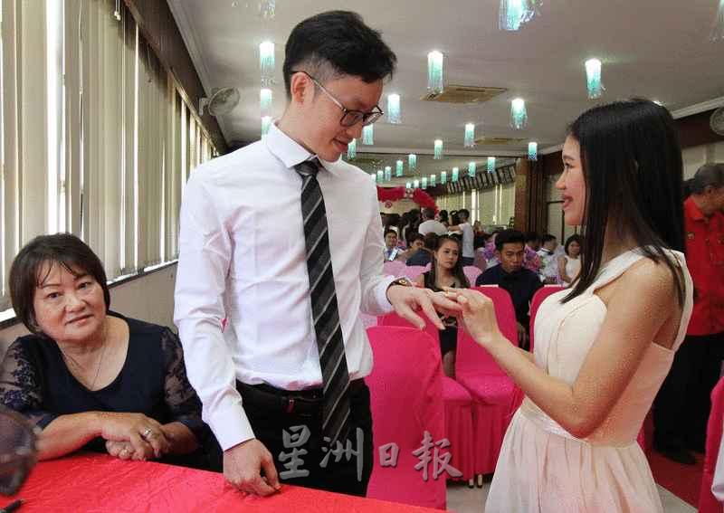 吴欣玲（右）甜蜜为丈夫杨成智戴上戒指。