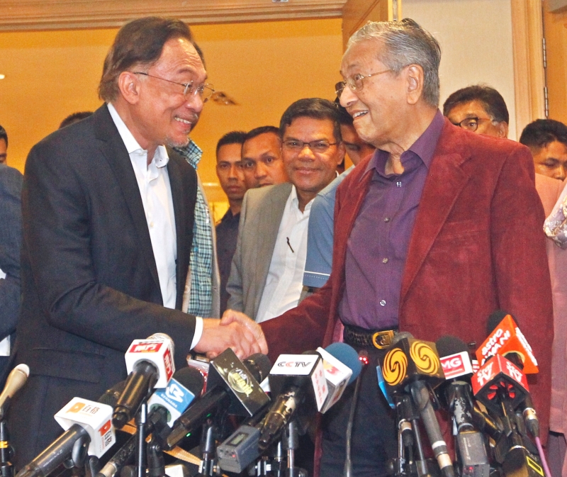 马哈迪（右）和安华在新闻发布前，握手为礼。
