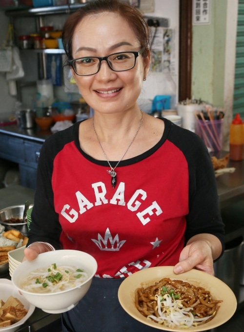 杨钰岚手里捧着的清汤和干捞濑粉撒上芝麻、芽菜和葱花，看似朴素寡淡，吃起来才知道这是对的，因为濑粉本身已经是最大的吸引！（图：星洲日报）