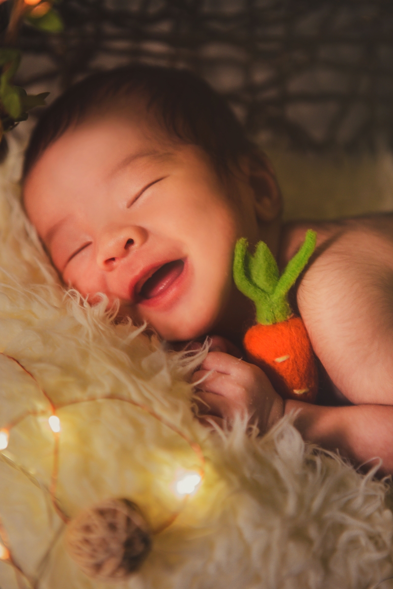 宝宝睡着时露出甜甜笑容的瞬间，被摄影师即时捕捉下来。（受访者提供）