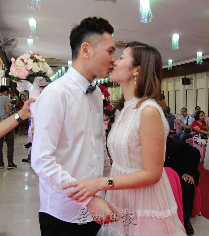在2020年2月22日注册结婚的彭俊威和潘韦敏签纸之后甜蜜亲吻。