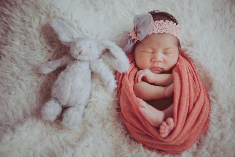 被裹布包裹起来的新生宝宝沉沉睡去，画面温暖和谐。（受访者提供）