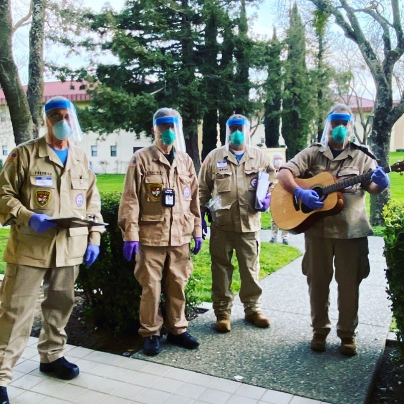 4位身穿防护衣、戴面罩和手套的医护人员，弹吉他大唱生日快乐歌。（互联网照片）
