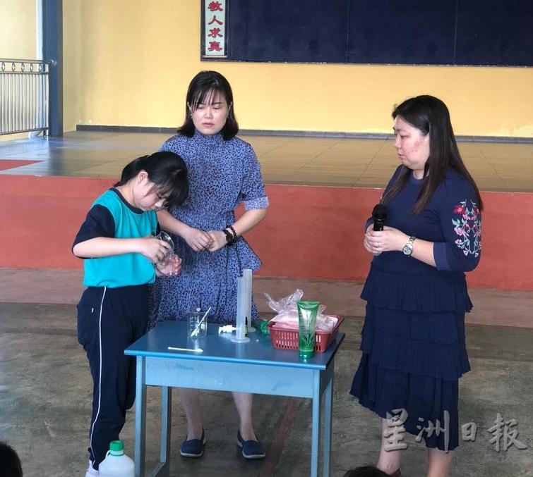 江雪芬（中）指导学生制作免洗洗手液。右为杨庆仪。