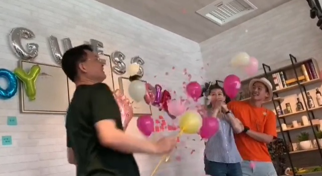 当粉色气球在空中飘浮，两人得知是女儿后都兴奋尖叫。