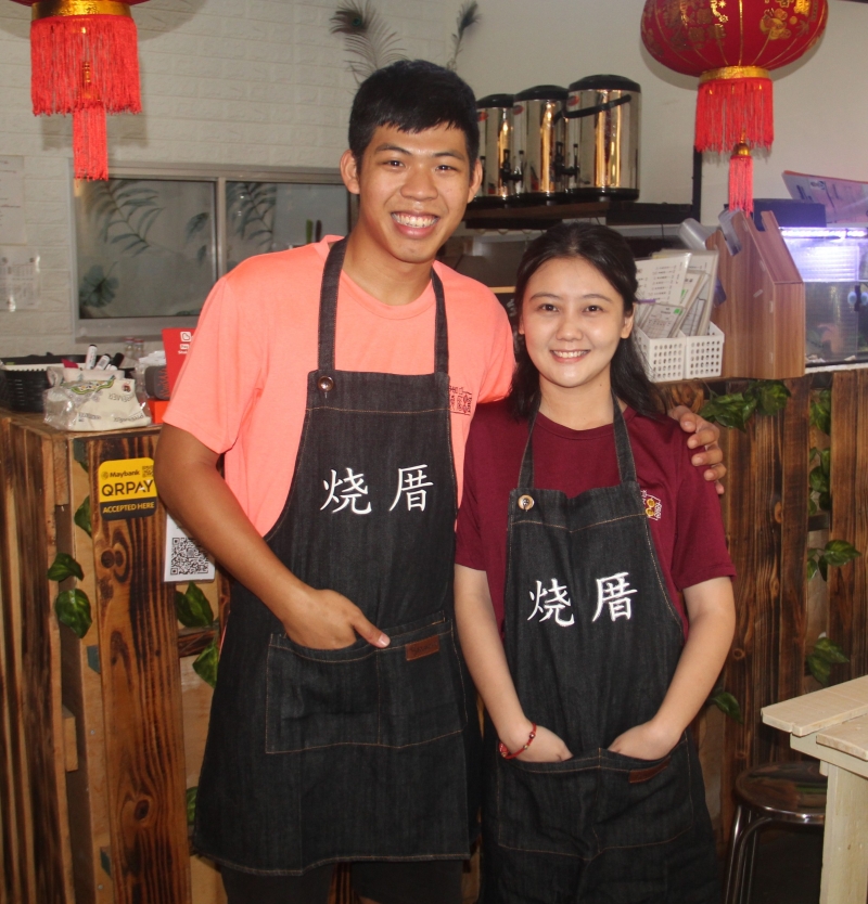 谢成凯（左）及江芮琦以“情侣档”姿态，携手经营“烧厝烧烤”台式美食专卖店。