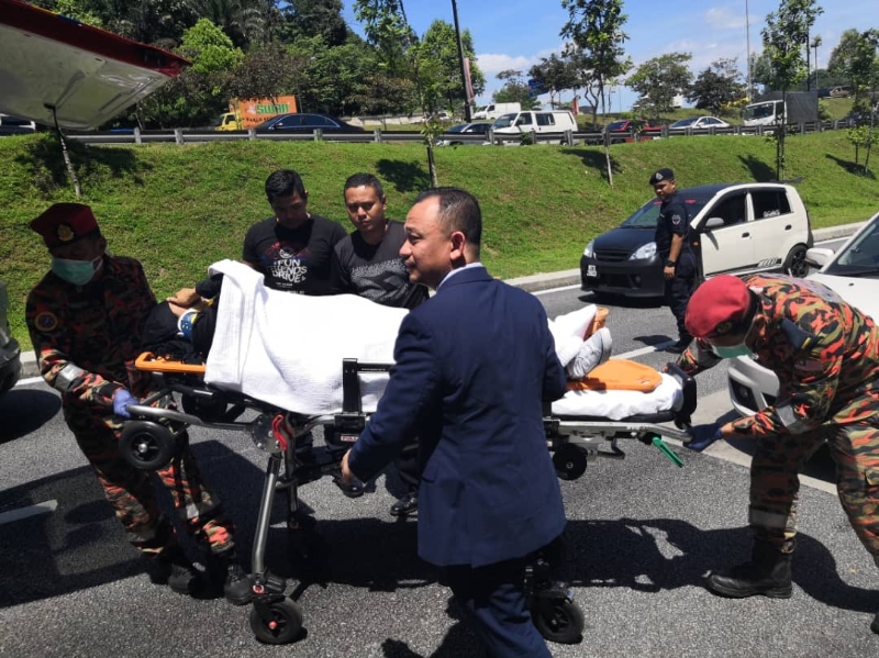 马马智礼协助消拯人员将车祸伤者送上救护车。