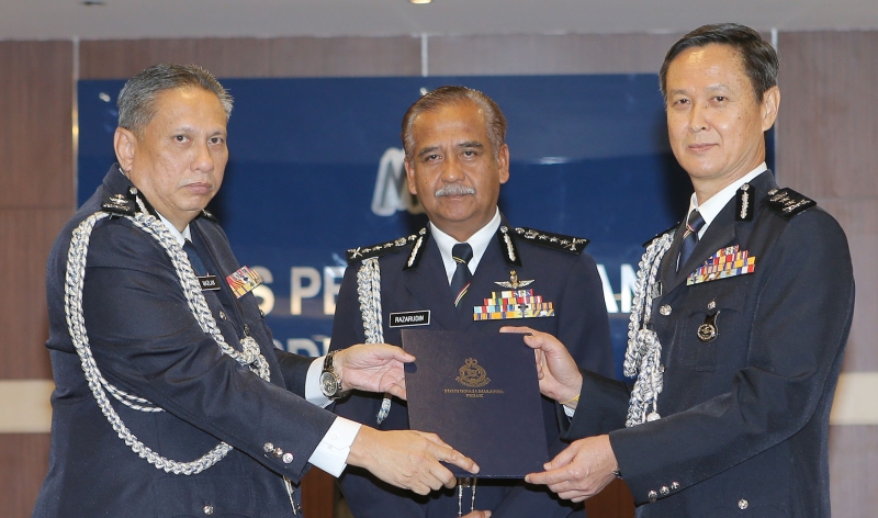 吴文恭（右起）在纳沙鲁丁见证下从马兹兰手中接过霹雳州副总警长职权。
