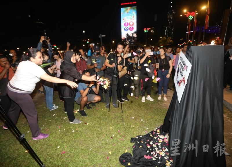 出席者向抗议纸牌掷花瓣，象征民主死亡。