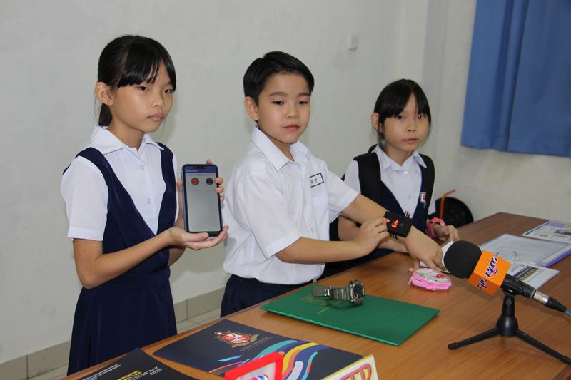 林君茹（左）说，父母只要按下手机上的App，孩子（林奕宁）戴在手上的设备就会响起。
