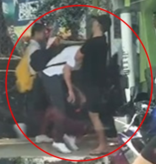 在社媒上流传的8秒钟短片里，红圈是其中1幕是涉嫌男中学生起腿以膝盖撞另一名男同学的腹部。（照片摘自短片）