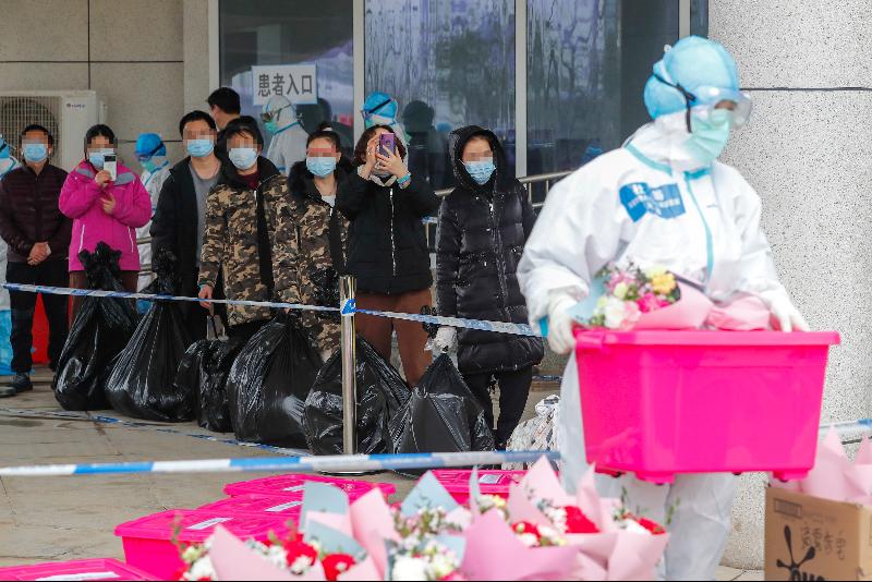 2月26日，武汉中医方舱医院首批23名治愈患者携带个人物品准备接受消毒后离开江夏方舱医院。（图：新华社）