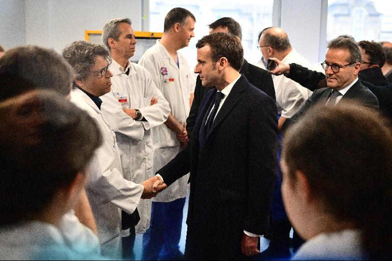 马克龙（右）到访巴黎13区公立医院，视察医疗团队情况并鼓舞士气。（图：法新社）