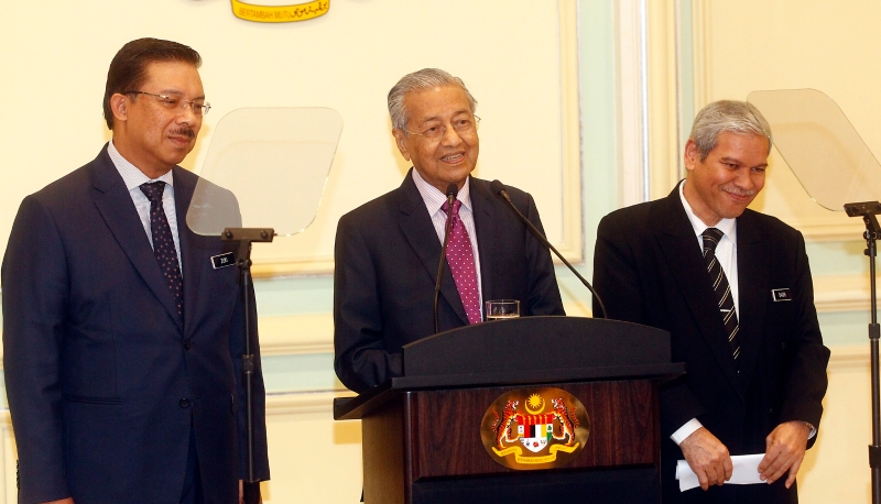 马哈迪（中）在政府首席秘书祖基（左）和财政部秘书长巴德里的陪同下宣布应对疫情的振兴经济配套。
