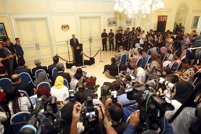 马哈迪（中）周四在首相署推出及公布200亿令吉的经济振兴配套，吸引大批媒体采访。