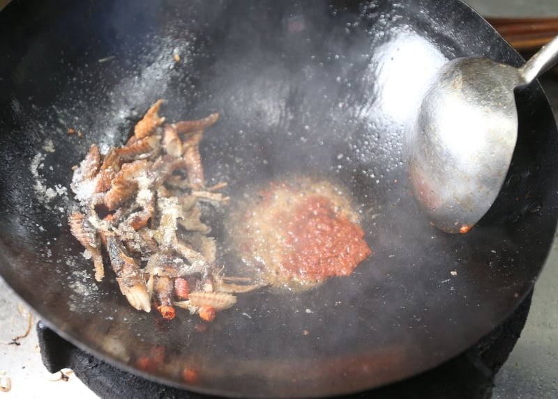 放入小辣椒、鱼肉、糖、胡椒粉炒至乾状，之后加入参峇、洋葱、糖及红辣椒翻炒。