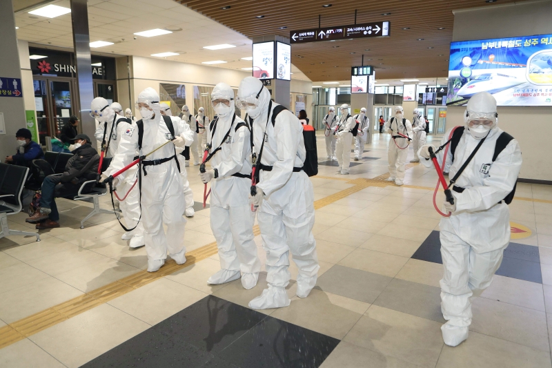 韩国军人套上防护衣，在大邱火车站喷洒消毒剂。（图：法新社）