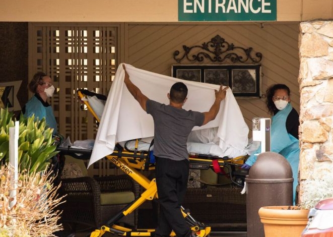 Healthcare workers transport a patient on a stretcher into an ambulance at Life Care Center of Kirkland in Kirkland, Washington. AFP Healthcare workers transport a patient on a stretcher into an ambulance at Life Care Center of Kirkland in Kirkland, Washington. AFP
