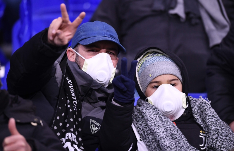 意大利严谨应对新冠肺炎疫情，图中的一位祖云杜斯球迷就与女儿戴上口罩去到球场支持爱队，做足保护措施。（图：法新社）