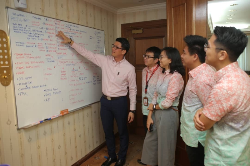 陈家兴（左一）向助理们叙述所要进行和正在进行的计划。
