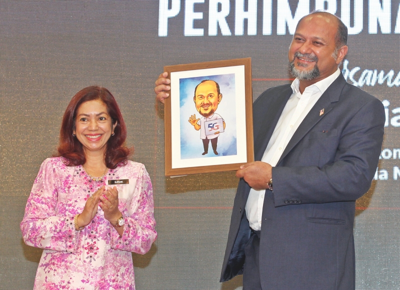 通讯部秘书长苏丽雅娜赠送卡通肖像予哥宾星做纪念。