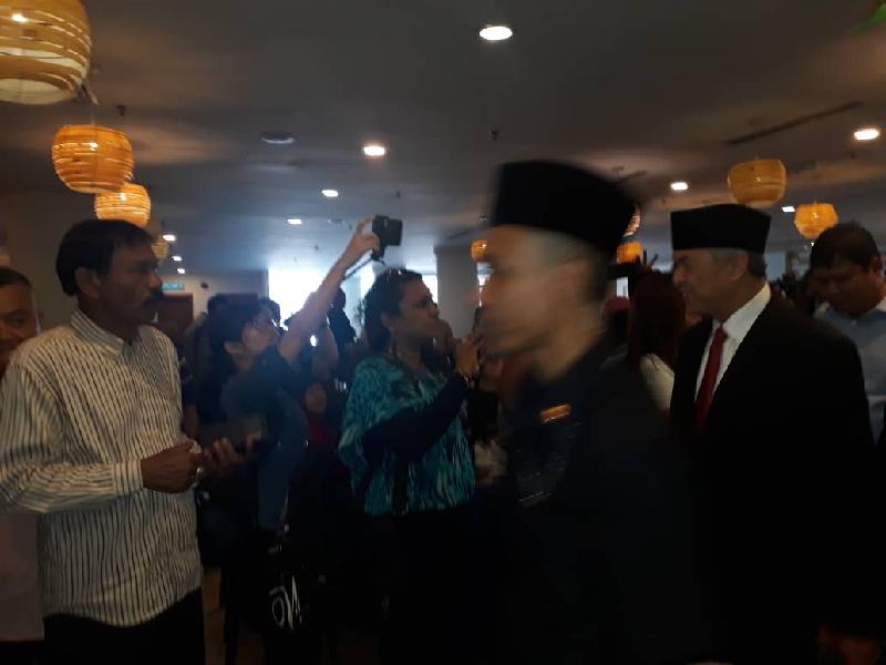 阿末扎希(右)抵达酒店时与在场者握手。