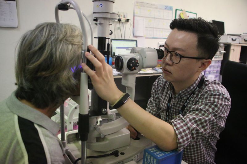 美里医院眼科专科医生黄伟伦（右）为民众验眼。
