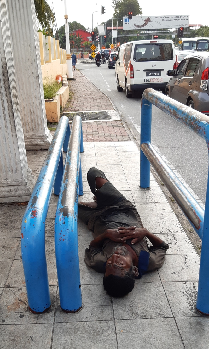 这名无家可归的流浪汉，无论在炎热天气或下大雨，都是在加影医院门口外面的巴士候车亭睡觉度日。