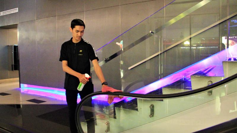 电影院员工正在使用消毒剂清洁电梯扶手，提升电影院的卫生指数，让顾客不会受到疫情的影响。