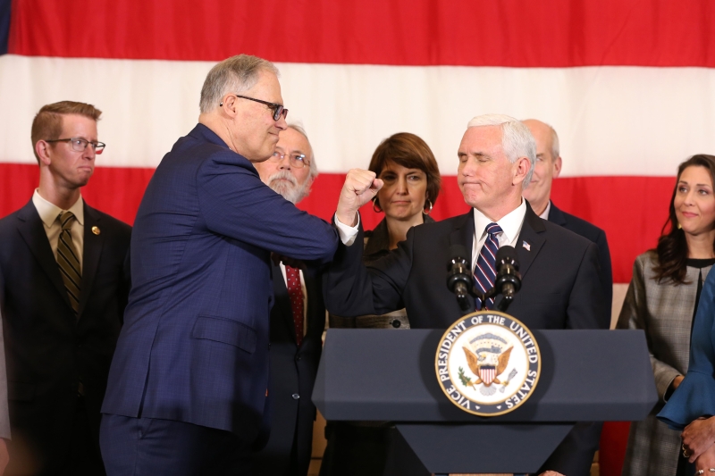 作为美国抗疫专家团队总指挥，副总统彭斯（右）前往华盛顿州会见州长因斯里（左），不能握手就以碰臂的方式打招呼 。（图：法新社）